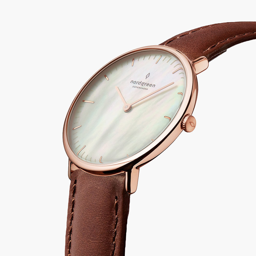 Close angle on the shimmering dial, rose gold-tone crown and brown strap.