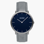 Watch with a navy blue dial and silver-tone case on a gray strap.