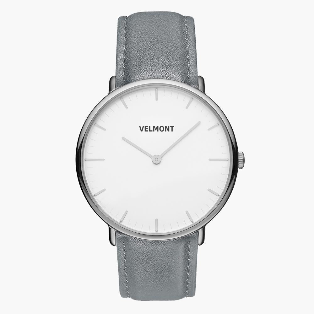 Minimalist watch with a white dial and silver-tone case on a gray strap.