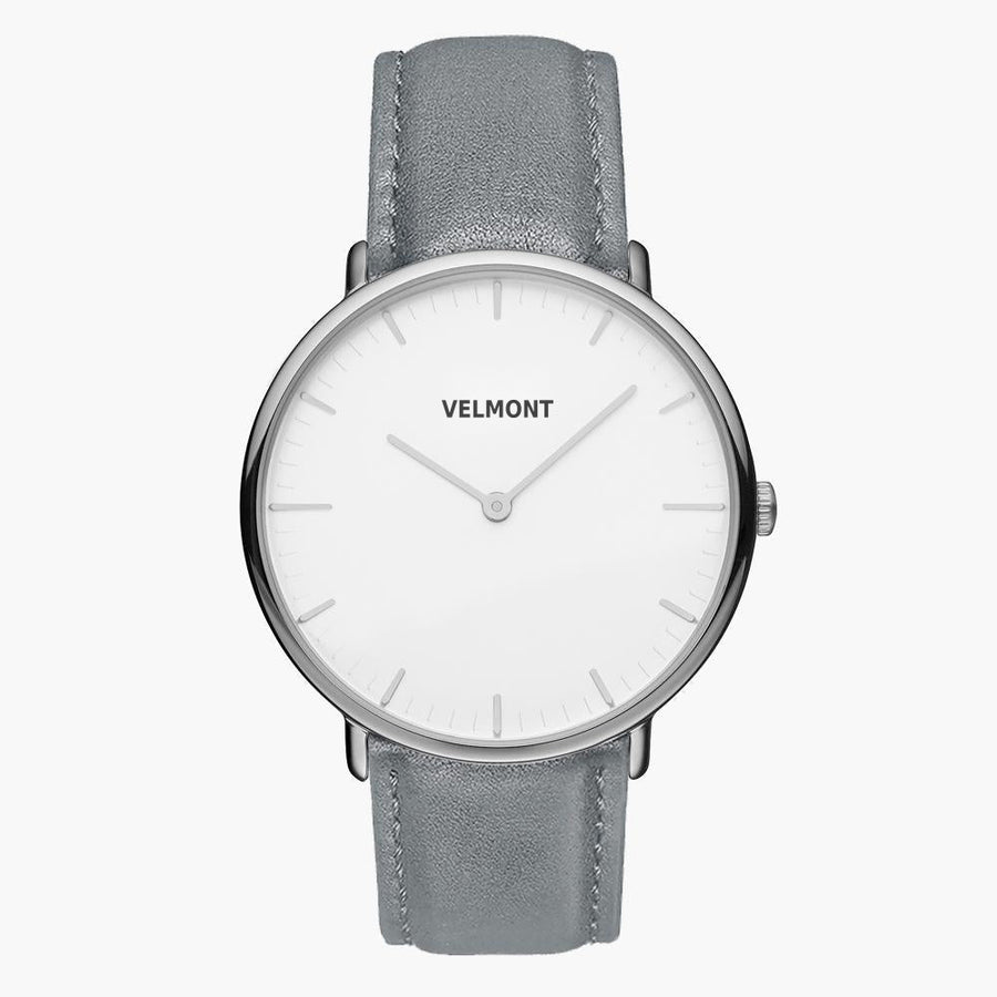 Minimalist watch with a white dial and silver-tone case on a gray strap.