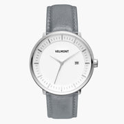 Watch with a white dial and silver-tone case on a gray strap, shown from the front.