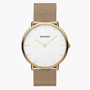 Minimalist watch with a white dial and gold-tone case on a gold-tone mesh strap.