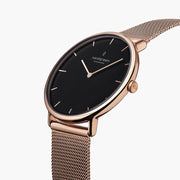 Three-quarter view of the watch showing the black dial and rose gold-tone mesh strap.