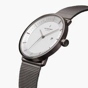 Watch turned at an angle, white dial and gunmetal bezel catching the light.