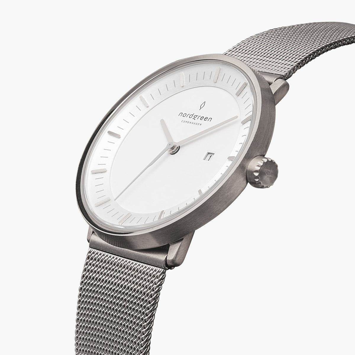 Watch turned at an angle, white dial and silver-tone bezel catching the light.