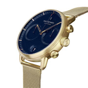 Angled view of the navy dial, two subdials and gold-tone pushers.