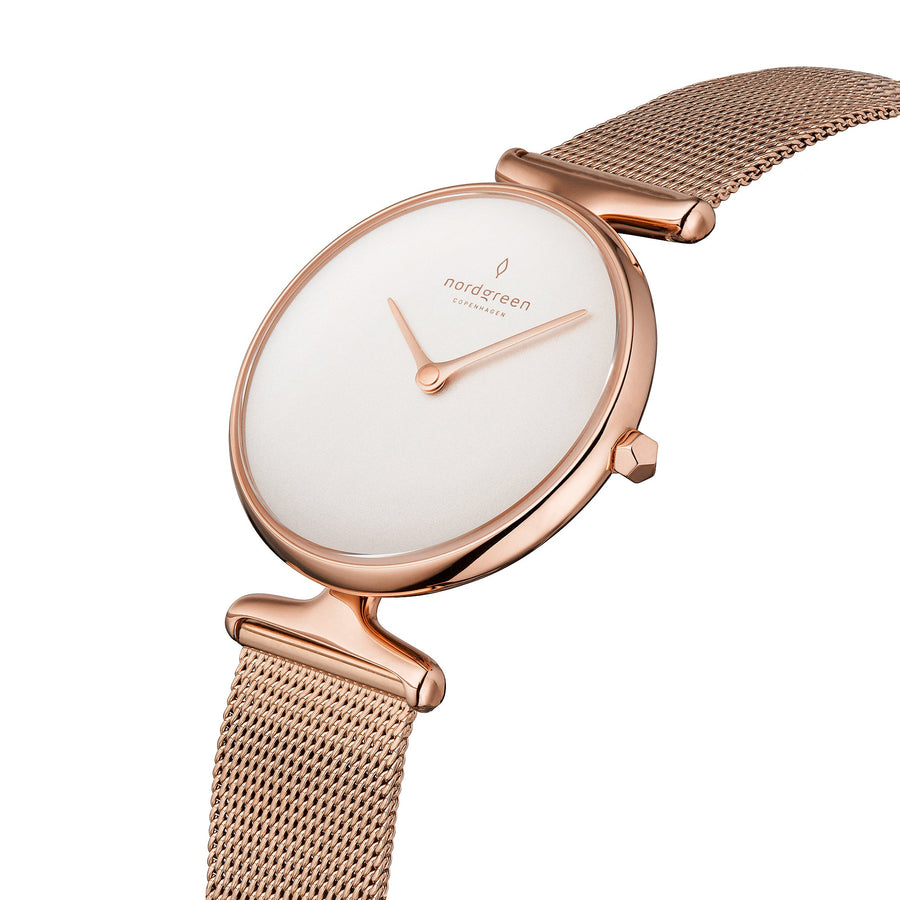 Angled look at the clean white dial and sculpted rose gold lugs.