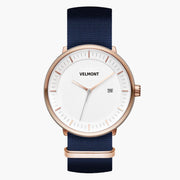 Watch with a white dial and rose gold-tone case on a navy woven strap.