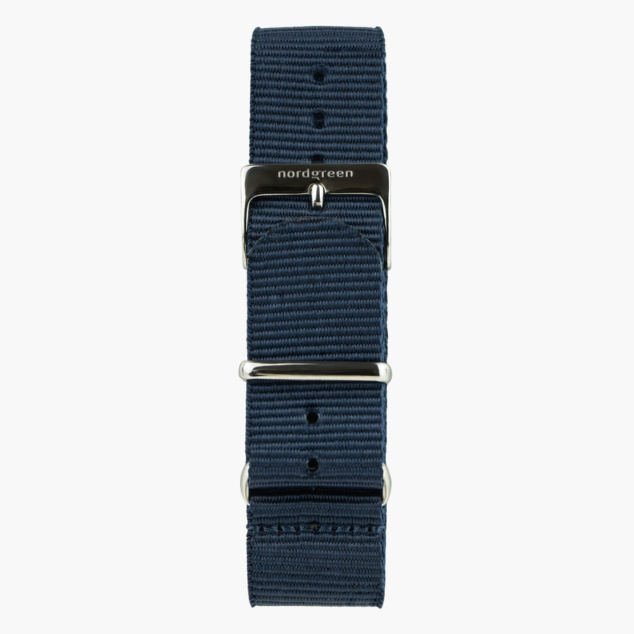 Navy ribbed nylon strap that passes under the case, with polished metal hardware.