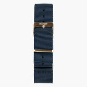 Navy woven strap with a light metal buckle and keepers, laid out flat.