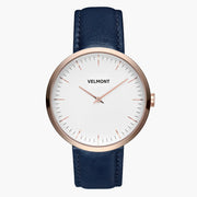 Watch with a white dial and rose gold-tone case on a navy blue strap, front view.