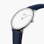 Three-quarter view of the slim silver-tone case on a navy strap.