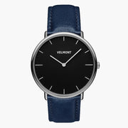 Watch with a black dial and silver-tone case on a navy strap, front view.