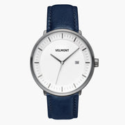 Watch with a white dial and gunmetal case on a navy strap, shown from the front.
