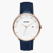 Watch with a white dial and rose gold-tone case on a smooth navy strap.