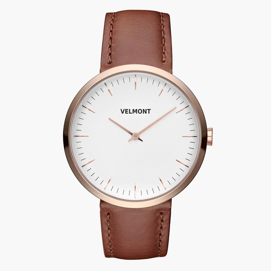 Minimalist watch with a white dial and rose gold-tone case on a caramel brown strap.