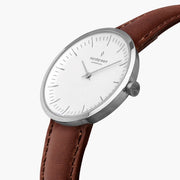 Angled view of the polished silver-tone case and minimalist white dial.