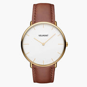 Watch with a gold-tone case and white dial on a smooth brown strap.
