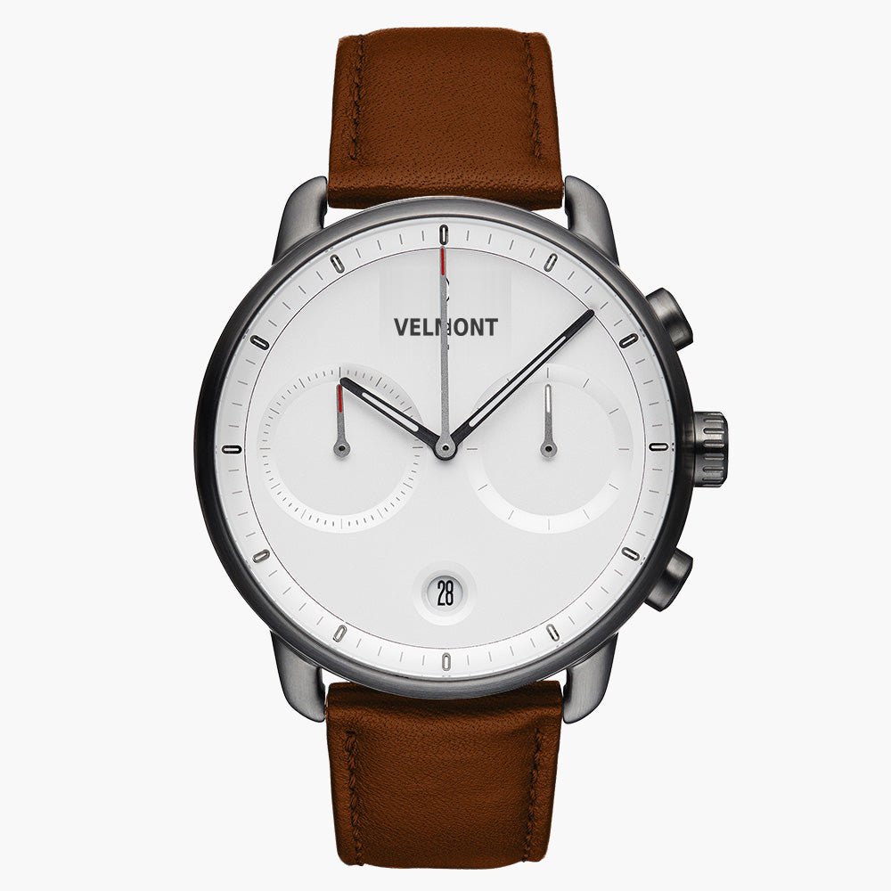 Chronograph-style watch with a white dial and gunmetal case on a brown strap.