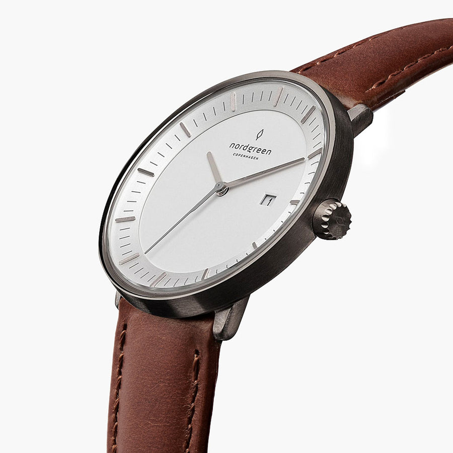 The gunmetal watch tilted to reveal its white dial and side crown.