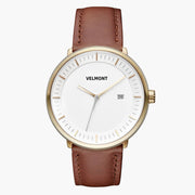 Front view of a gold-tone watch with a white dial on a brown strap.