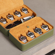 Open travel case holding eight watches and sunglasses