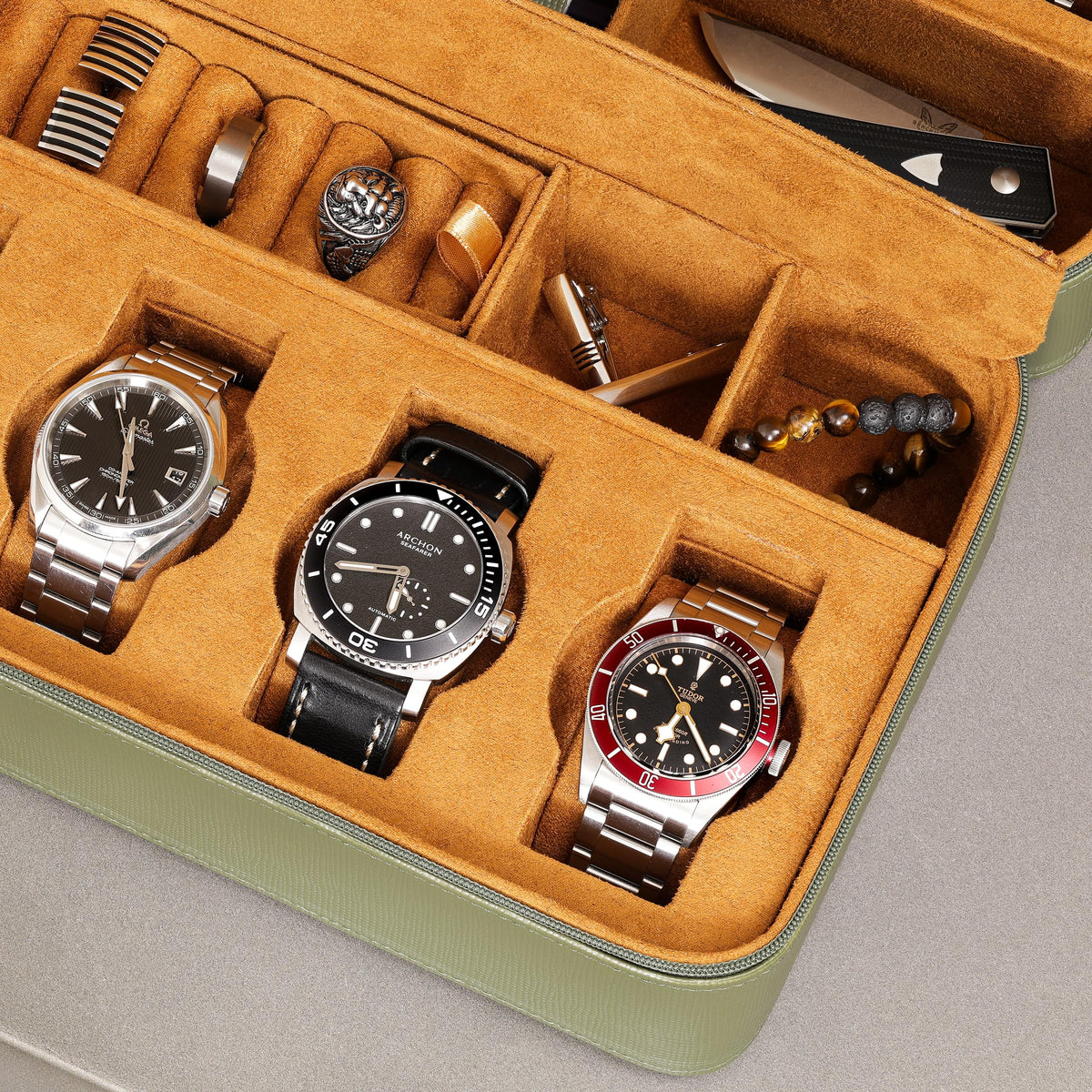 Close-up of watches and accessories inside the tan-lined case