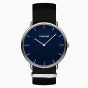Watch with a navy blue dial and silver-tone case on a black woven strap.