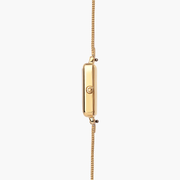 Thin side view of the gold case with its crown and mesh band.