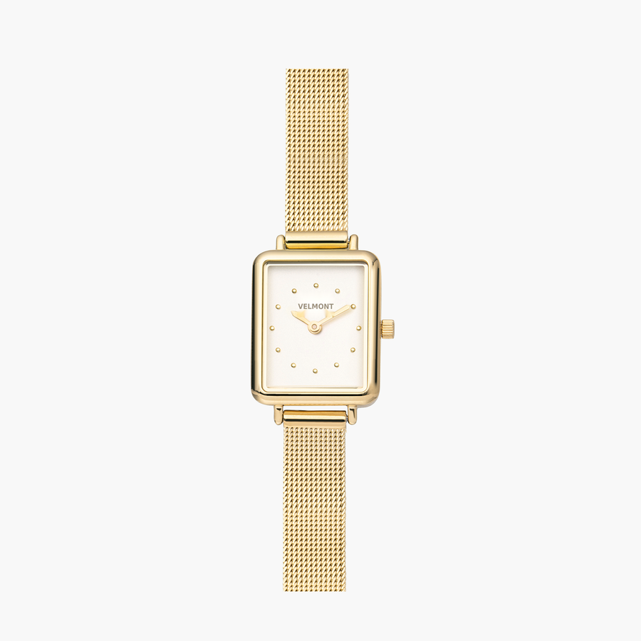 Small rectangular gold-tone watch with a white dial on a fine mesh strap.