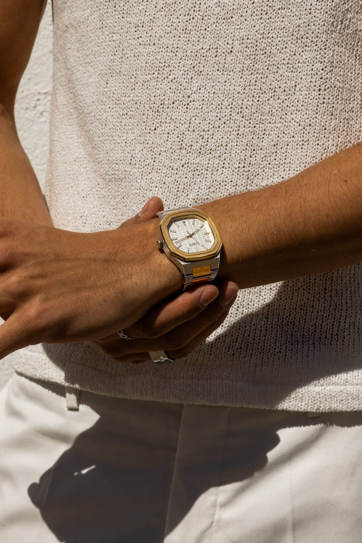 Watch on a wrist against a knit sweater