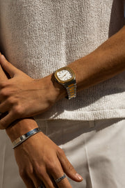 Arms crossed over a knit top, watch on the wrist