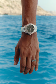Close-up of the watch on the wrist, sea in the background