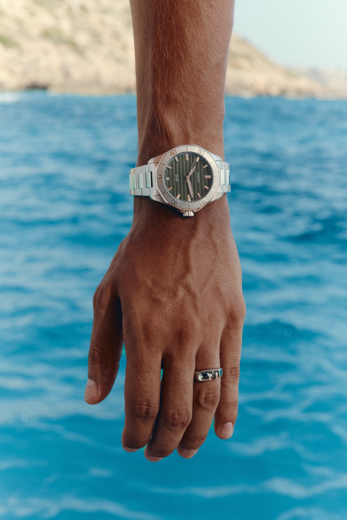 Close-up of the watch on the wrist, sea in the background