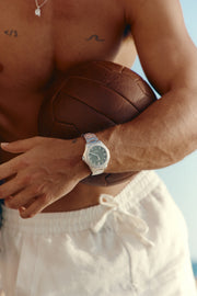 Green-dial automatic watch worn while holding a leather ball