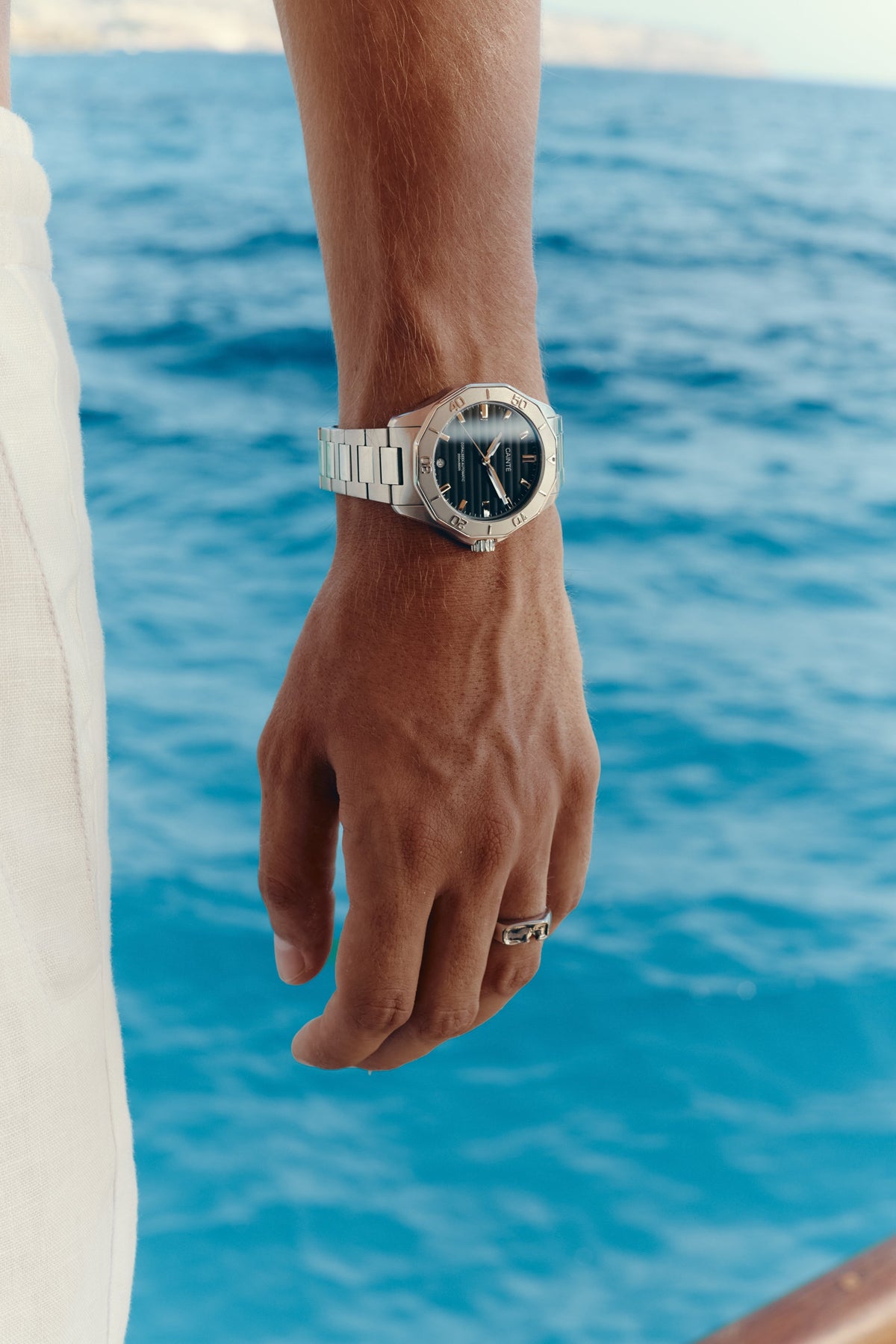 Close-up of the watch on the wrist, sea in the background