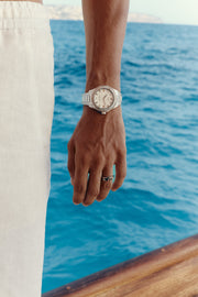 Close-up of the watch on the wrist, sea in the background