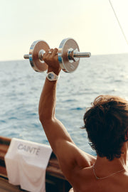 Man lifting a dumbbell on deck with the watch on