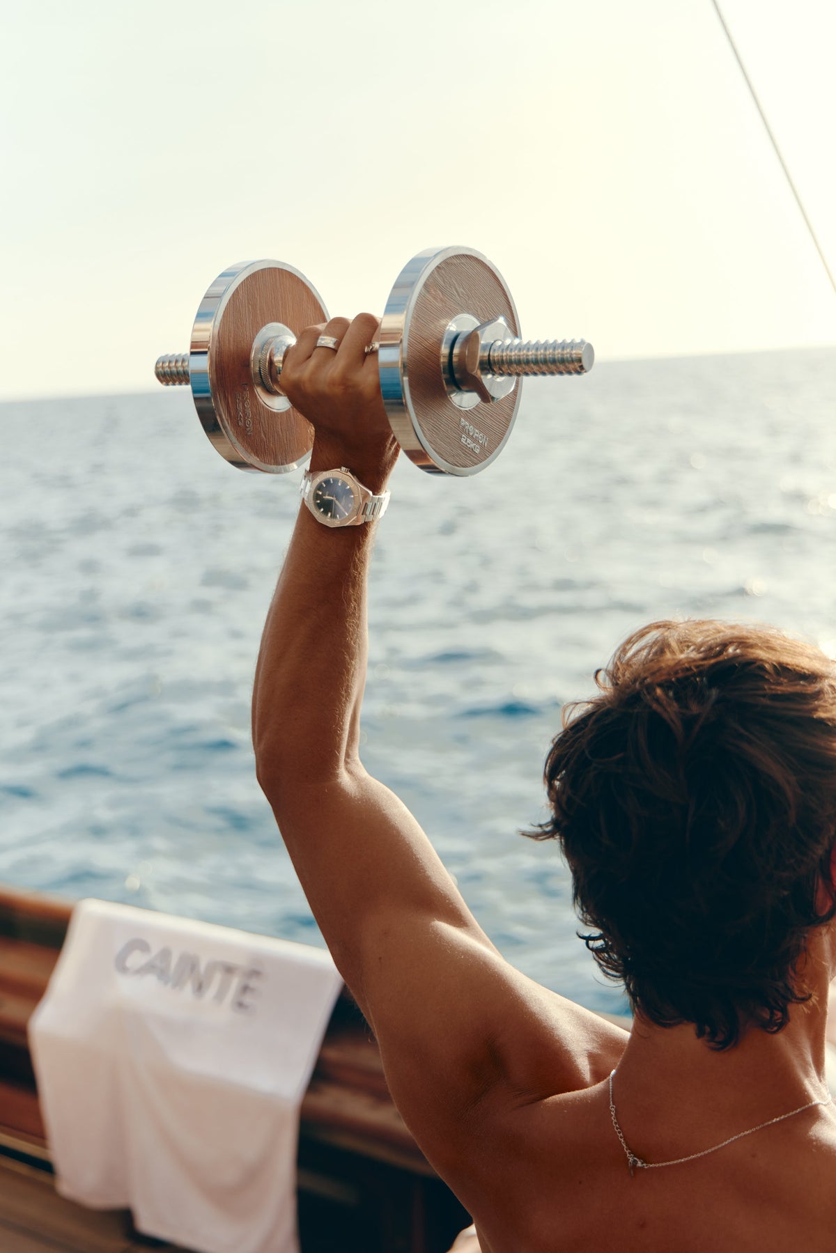 Man lifting a dumbbell on deck with the watch on