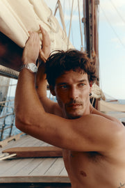 Man on deck with arms raised, watch on the wrist