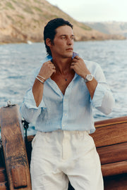 Man standing on the deck of a sailboat wearing the watch