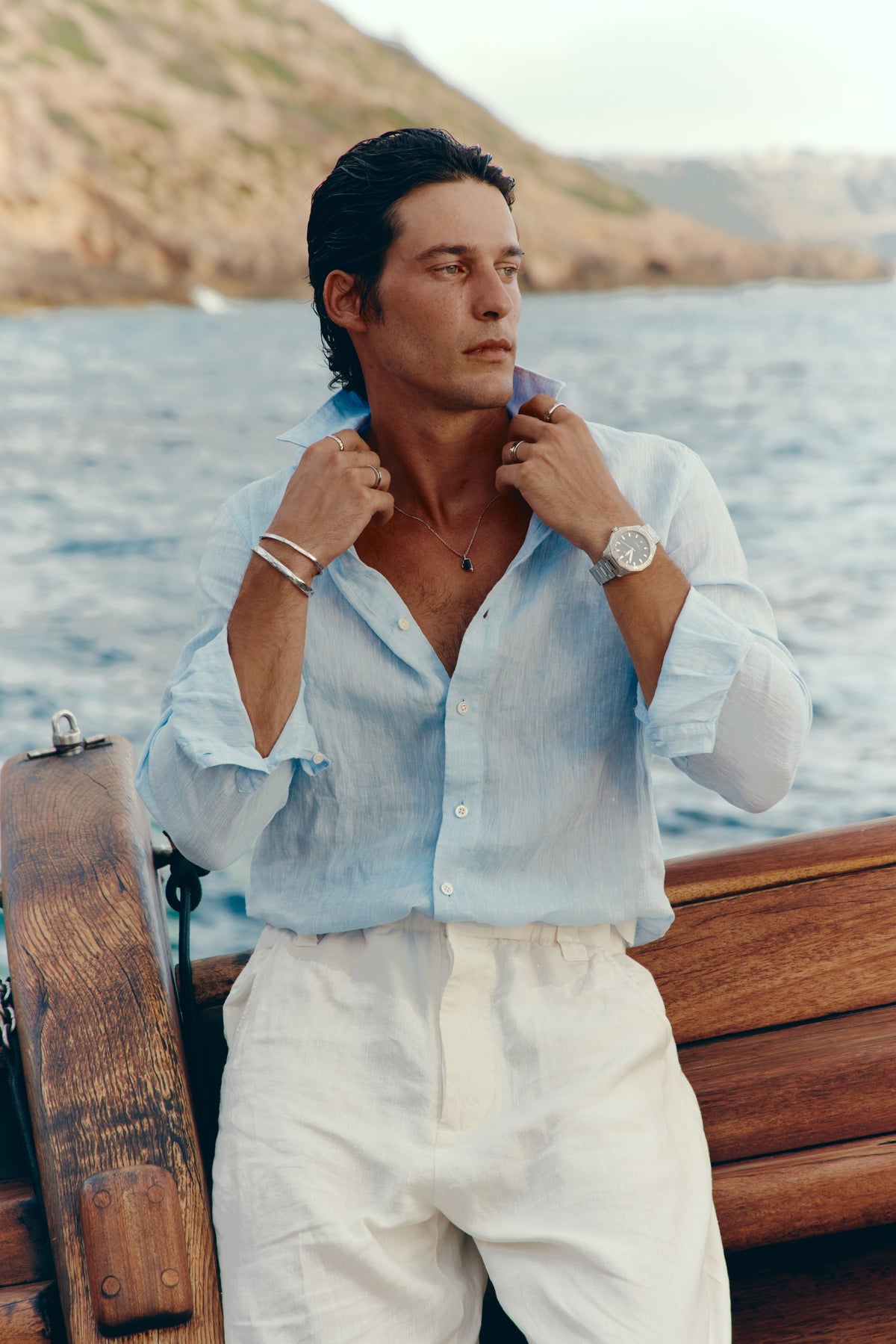 Man standing on the deck of a sailboat wearing the watch