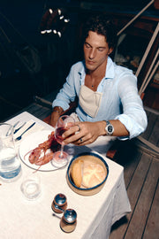 Man at a set table on a boat wearing the watch