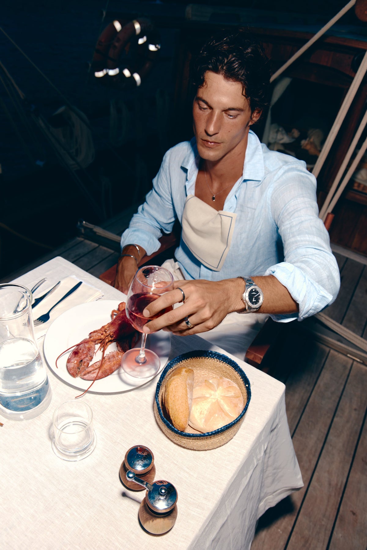 Man at a set table on a boat wearing the watch