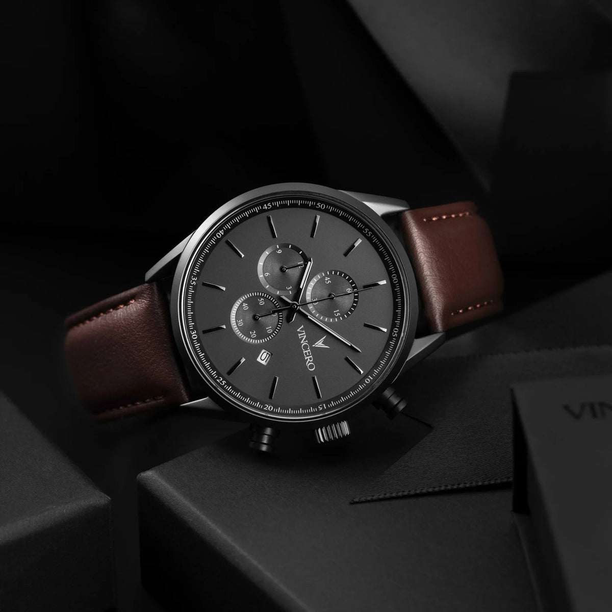 Gunmetal chronograph lying on a dark box