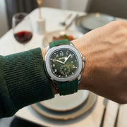 Green-dial watch with green rubber strap worn at a dinner table