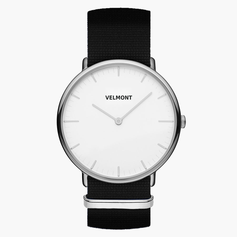 Minimalist watch with a white dial and silver-tone case on a black woven strap.