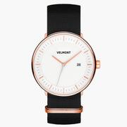 Watch with a white dial and rose gold-tone case on a black woven strap.