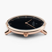 Low side angle of the rose gold-tone case with the black dial in view.
