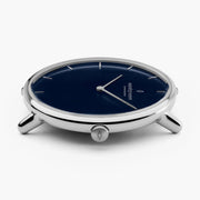 The thin silver-tone case from a low angle, slender lugs and crown visible.